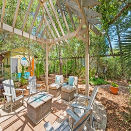 Outdoor seating area with a pergola and gas firepit.